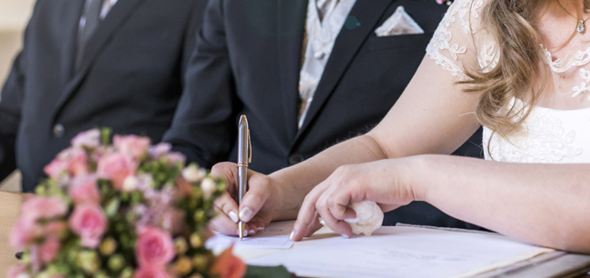 marriage elegant bride signing register, holding pen and official document wedding couple